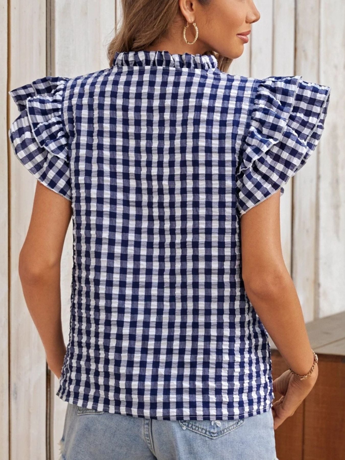 Royal blue gingham blouse with ruffled short sleeves and a mock neckline.