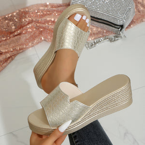 Gold crocodile-embossed open-toe wedge sandals with a textured sole.