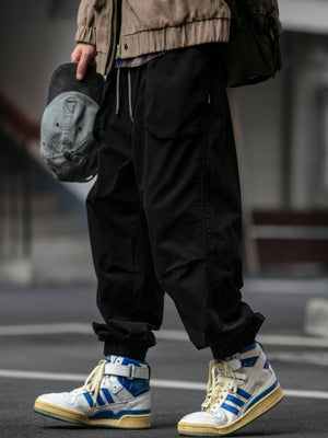 Black sweatpants with drawstring waist and cargo pockets, cuffed ankles.