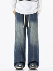 Relaxed fit wide-leg jeans in dark wash denim with drawstring waist and panel detail.