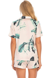 Botanical print satin pajama set in blush pink with short sleeves and shorts.