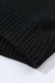 Black acrylic knit cardigan detail showing ribbed texture and hem
