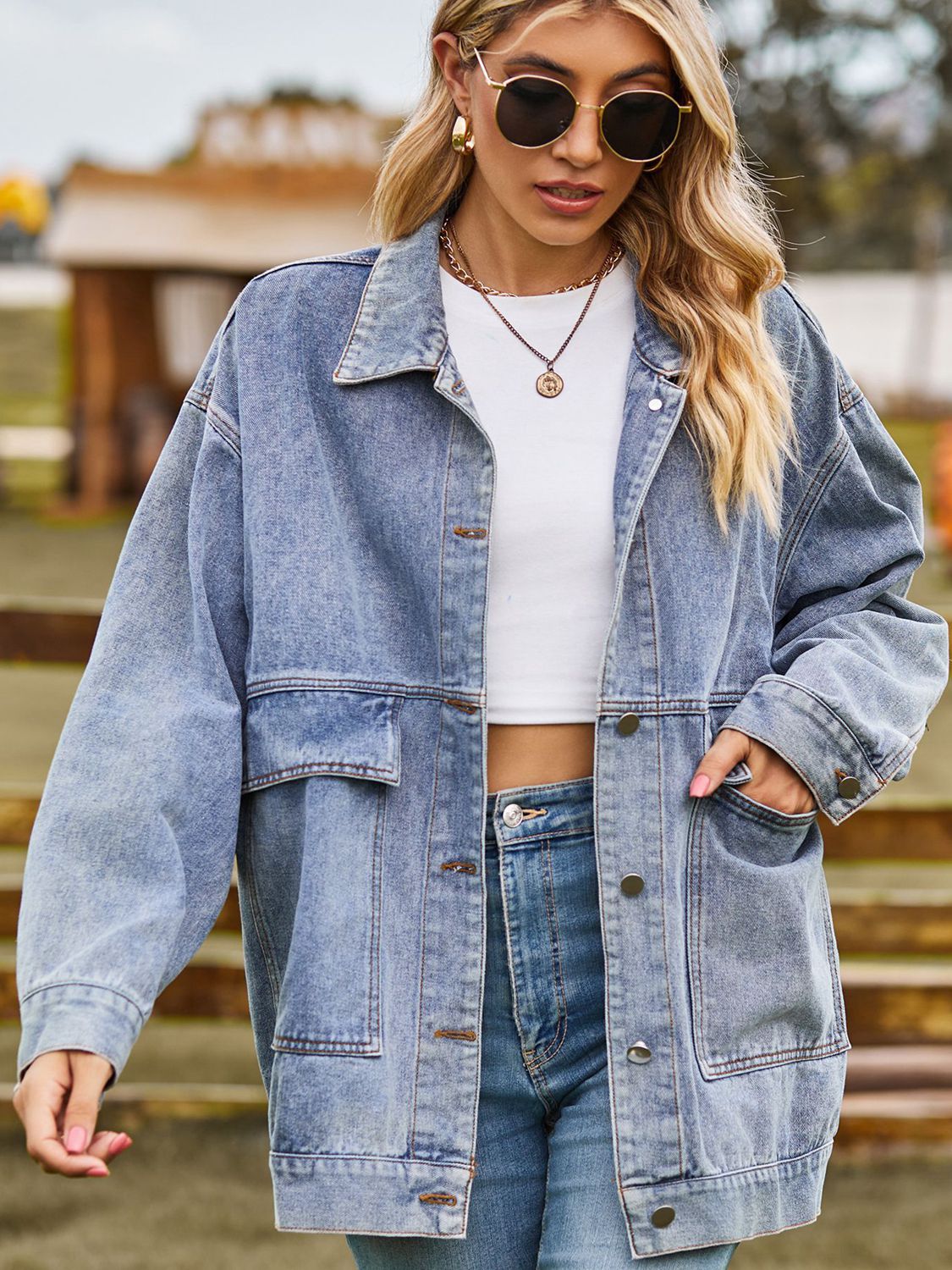 Oversized denim trucker jacket in light wash with collared neck and chest pockets.