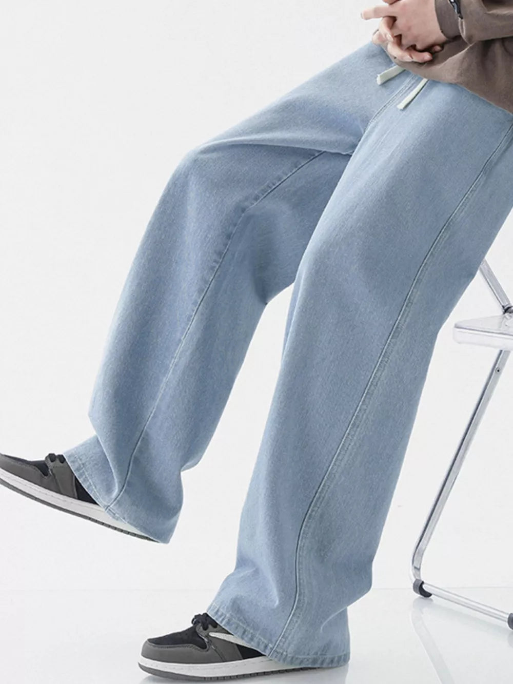 Light blue relaxed wide-leg jeans with drawstring detail.