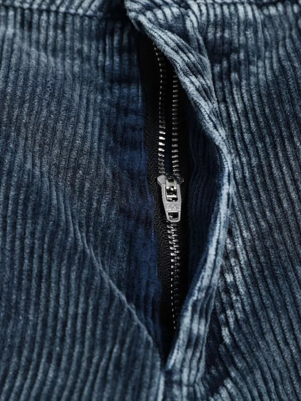 Blue corduroy cargo pants with a zipper detail and textured fabric.