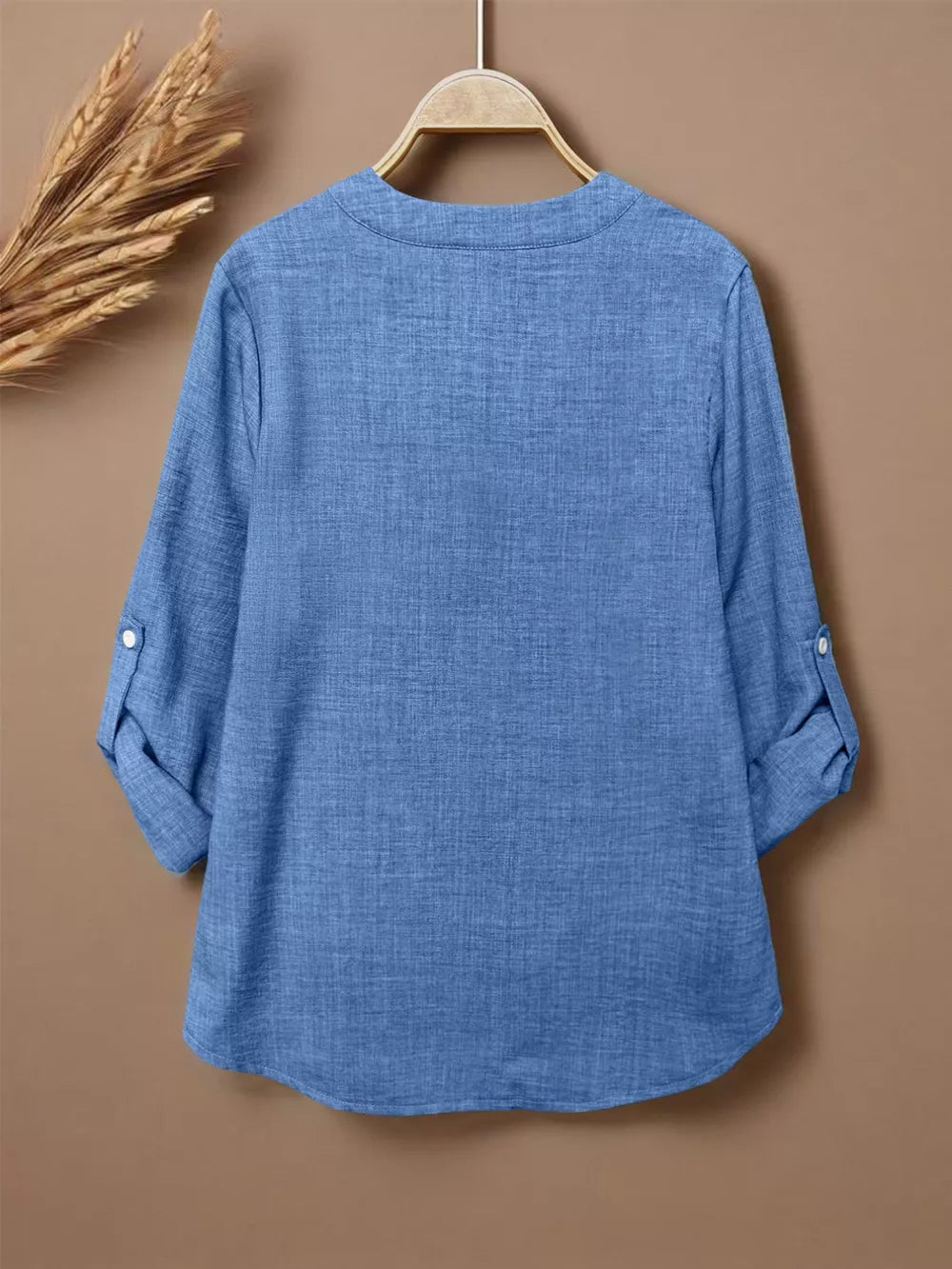 Blue textured maternity shirt with notched V-neck, roll-tab sleeves, and curved hem