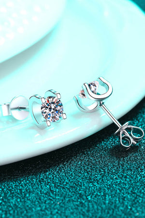 Silver moissanite stud earrings with sculpted heart and horseshoe settings.