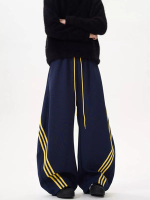 Navy wide-leg sweatpants with yellow stripes and drawstring waist.