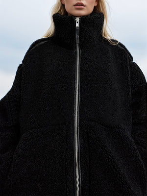 Black teddy fleece zip-up jacket with contrast piping and high neck.