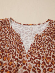 Smocked ruffled print blouse with V-neck and animal print pattern.