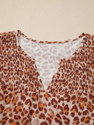 Smocked ruffled print blouse with V-neck and animal print pattern.