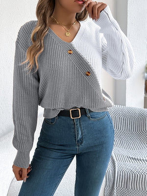 Asymmetrical colorblock knit sweater in gray and white with button detail.