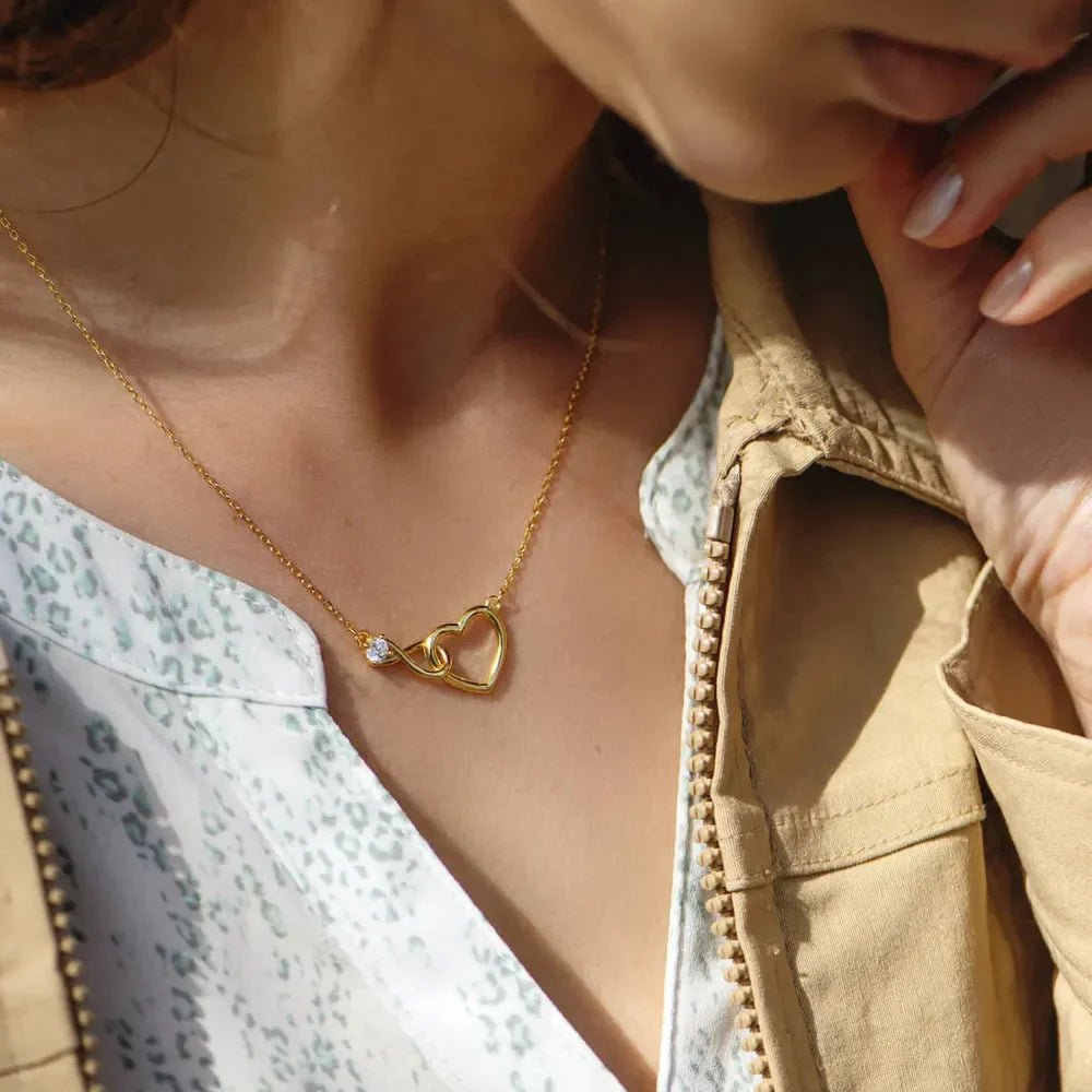 Gold necklace with intertwined heart and infinity symbols, accented with a cubic zirconia.