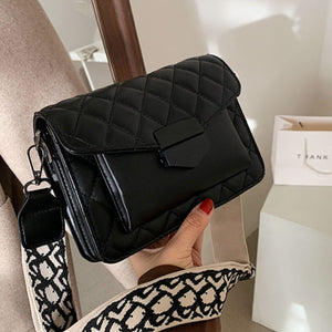 Black quilted flap crossbody bag with geometric strap detail