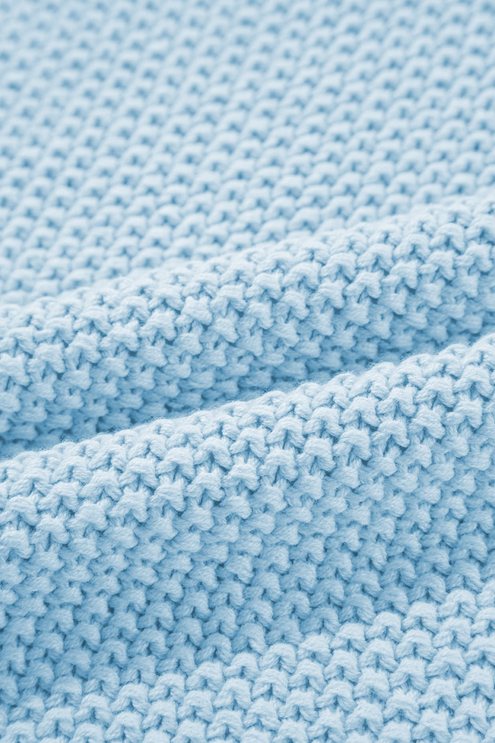 Light blue knit turtleneck sweater detail with textured stitch and soft fabric.