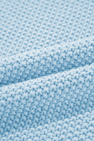 Light blue knit turtleneck sweater detail with textured stitch and soft fabric.