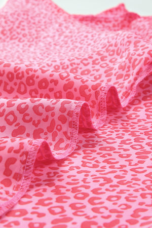 Pink leopard print blouse with smocked sleeve detail and ruffled hem.