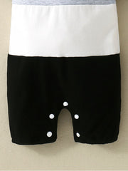 Baby cotton one-piece with color block gray, white, and black panels and snap closure.