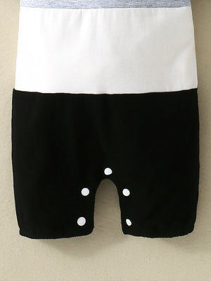 Baby cotton one-piece with color block gray, white, and black panels and snap closure.