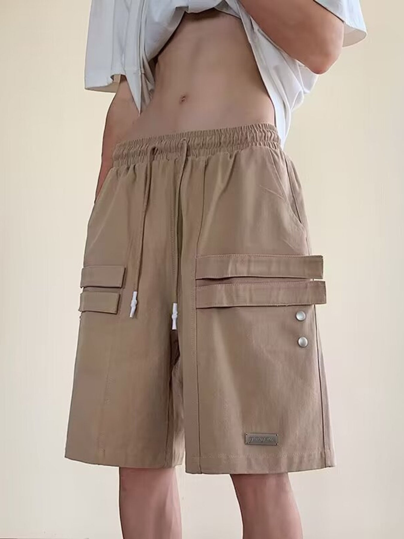 Camel cargo shorts with drawstring waist and multiple flap pockets.