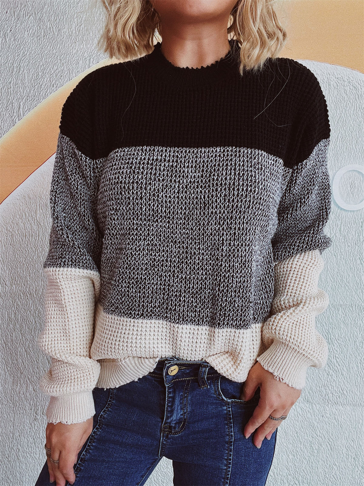 Colorblock textured knit pullover sweater with black, gray, and cream panels.