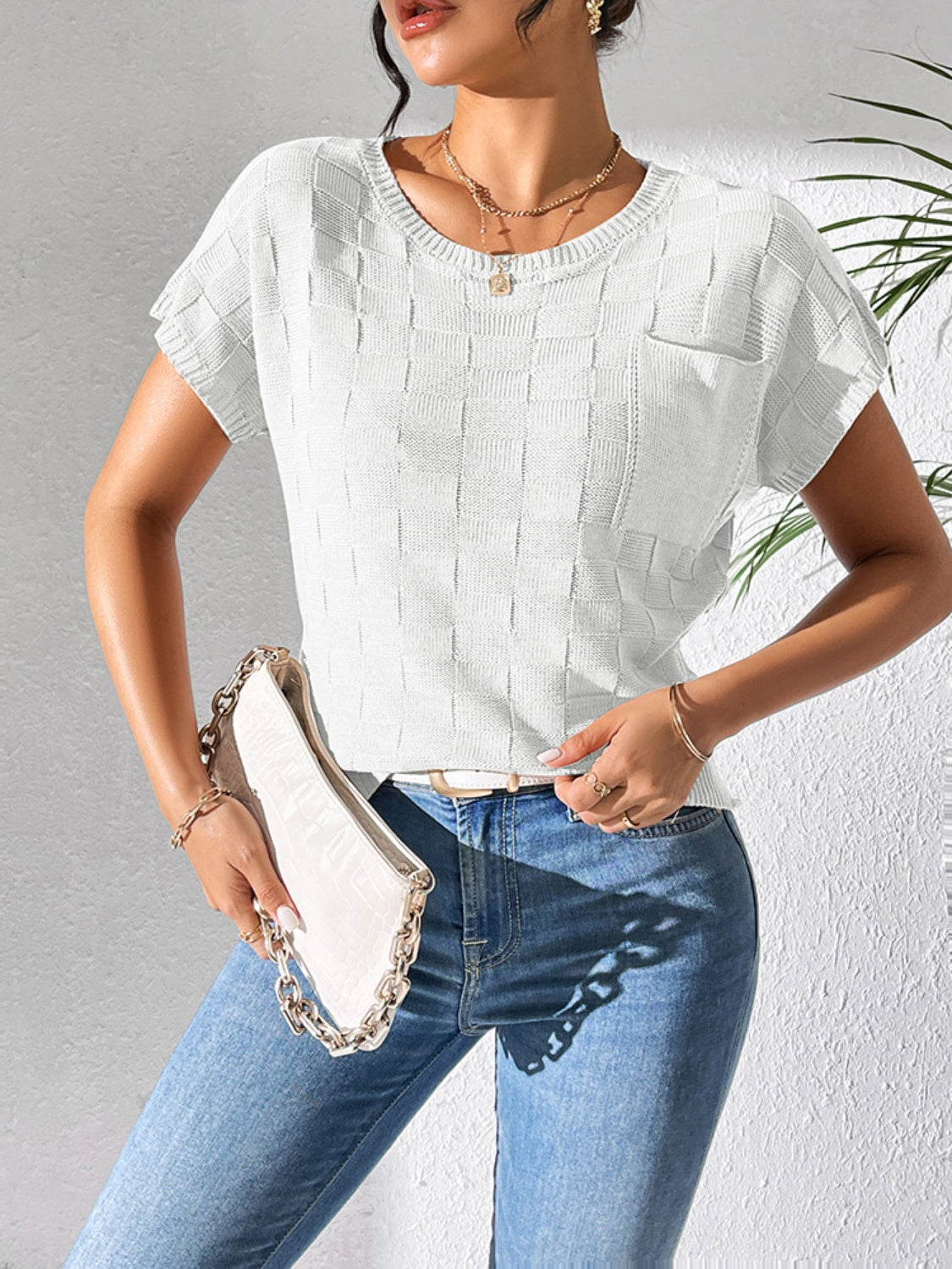 White textured knit pocket tee with short sleeves and crew neck, styled with jeans and a clutch.