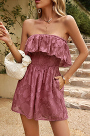 Strapless embroidered romper in dark green with ruffled neckline and smocked waist.