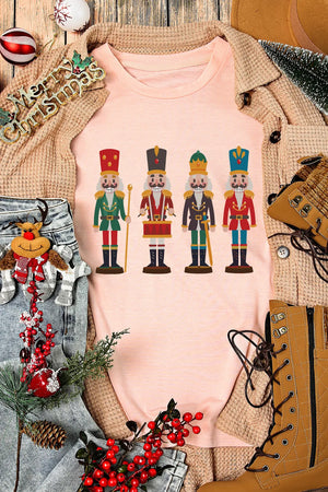 Blush pink t-shirt with a graphic print of four nutcracker soldiers in colorful uniforms.
