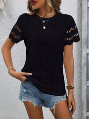 Black eyelet blouse with scalloped short sleeves and a textured pattern.