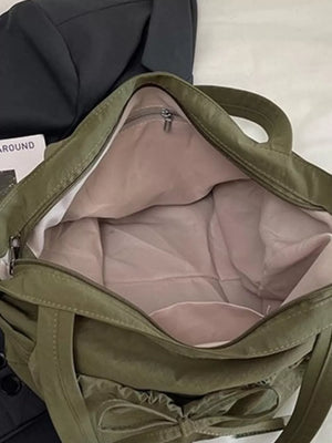 Olive green nylon tote bag with bow detail and open interior.