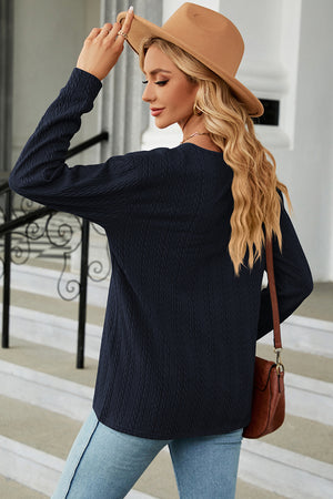Dark blue textured cable-knit henley pullover with long sleeves.