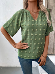 Moss green Swiss dot blouse with V-neck and short puff sleeves.