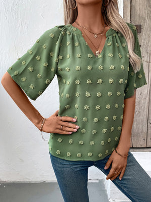 Moss green Swiss dot blouse with V-neck and short puff sleeves.