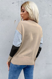 Geometric panel knit sweater in tan with gray and black sleeves, crewneck, casual style.