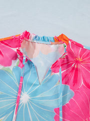 Tie neck blouse with bright floral print, ruffled collar, and V-neck with ties.