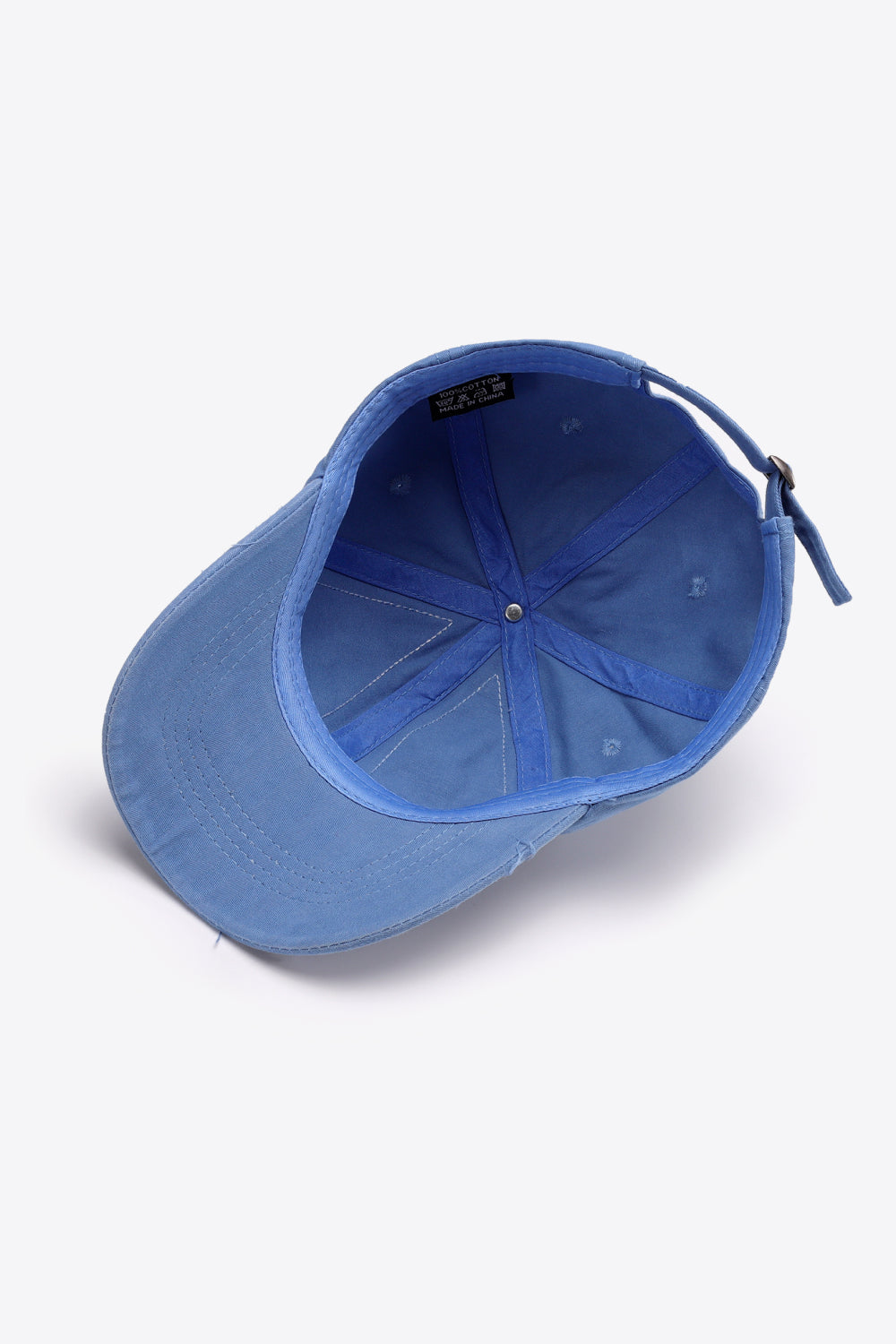 Raw edge denim baseball cap in Cobalt Blue with adjustable strap and visible interior label.
