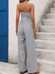 Strapless wide leg romper with smocked bodice and navy and white vertical stripes.