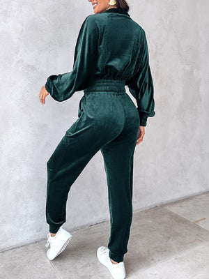 Velvet track jacket in deep teal with cinched waist and balloon sleeves, paired with matching pants.