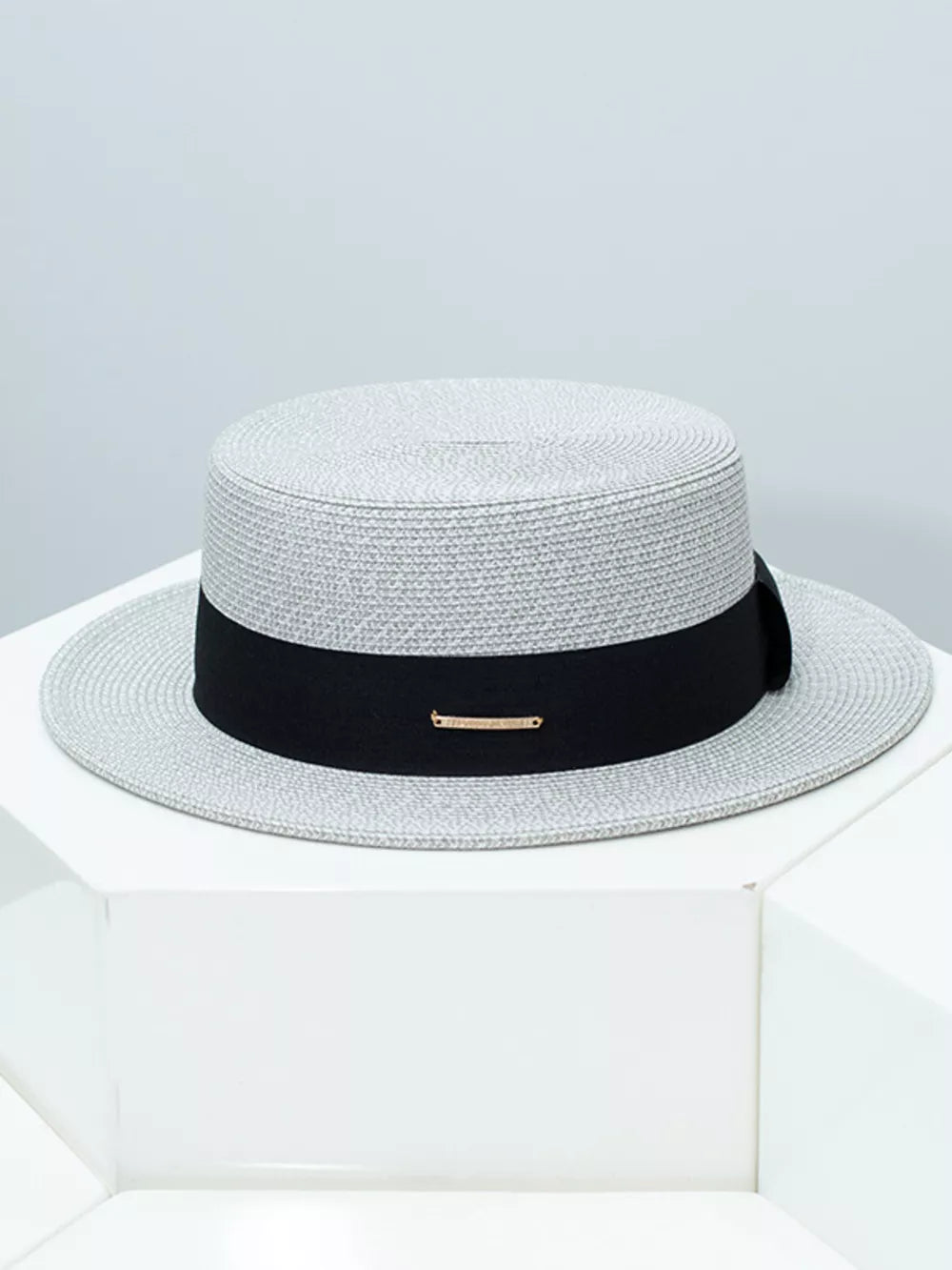 Gray straw boater hat with black ribbon and gold accent detail
