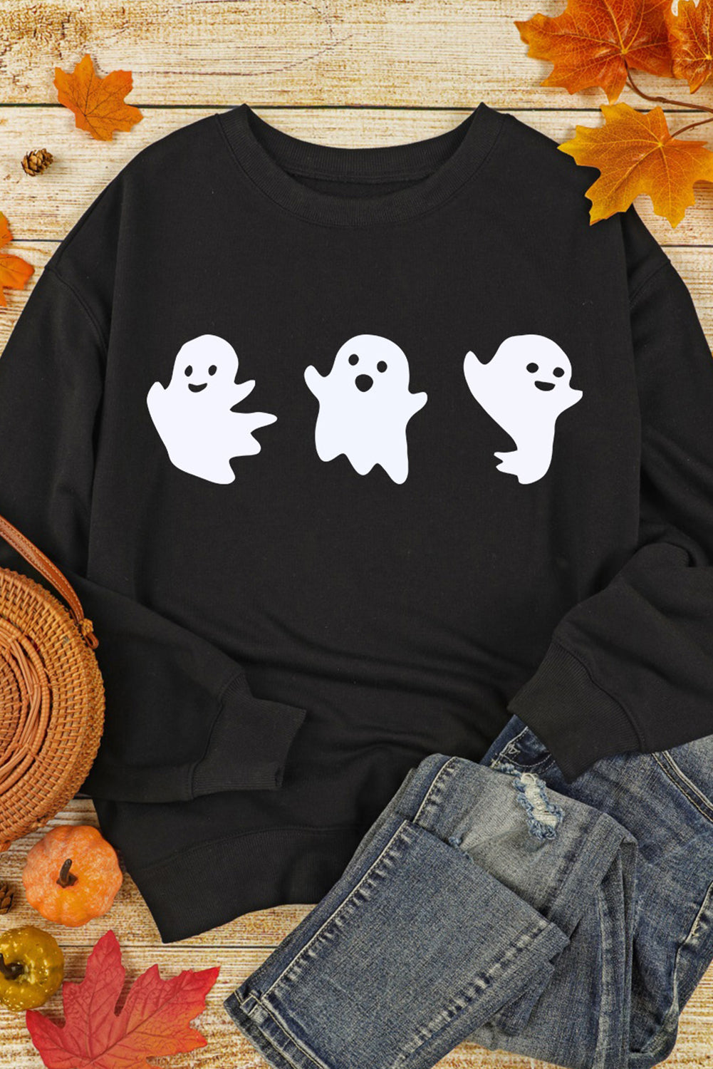Black crewneck sweatshirt with a spooky trio of white ghost graphics, crew neck, long sleeves.