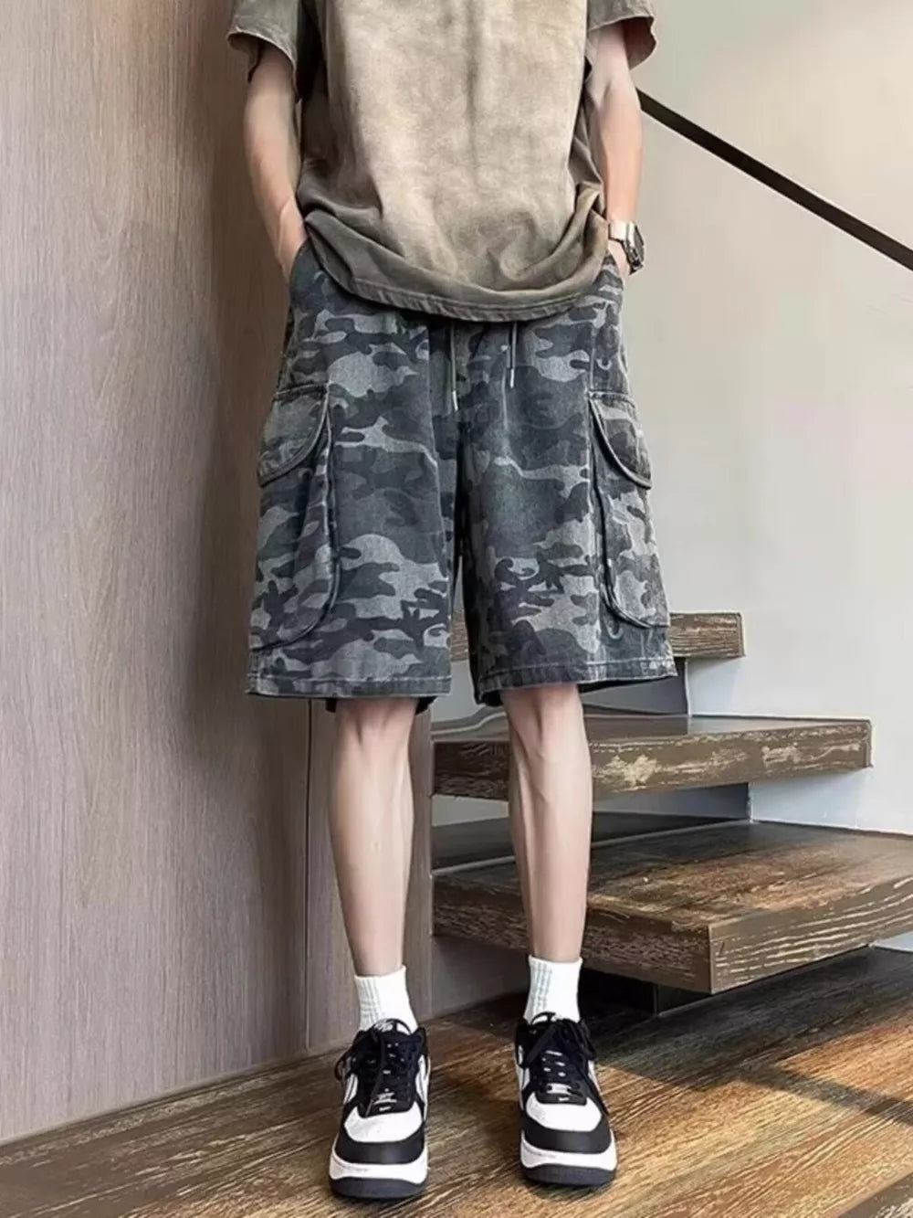 Relaxed fit black camo cargo shorts with multiple pockets and drawstring waist.