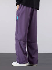 Purple cargo pants with loose fit and zippered pocket detail.