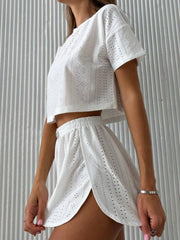 White perforated crop top and shorts set with elastic waist and side slits.