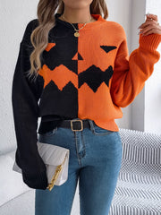 Split-face pumpkin knit sweater in orange and black with a crew neck and long sleeves.