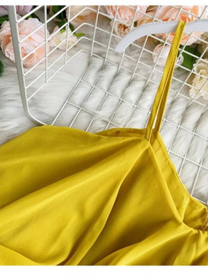 Yellow camisole with spaghetti straps and delicate ruffles.