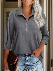 Textured dark gray zip-front polo top with a ring zipper pull and cuffed sleeves.