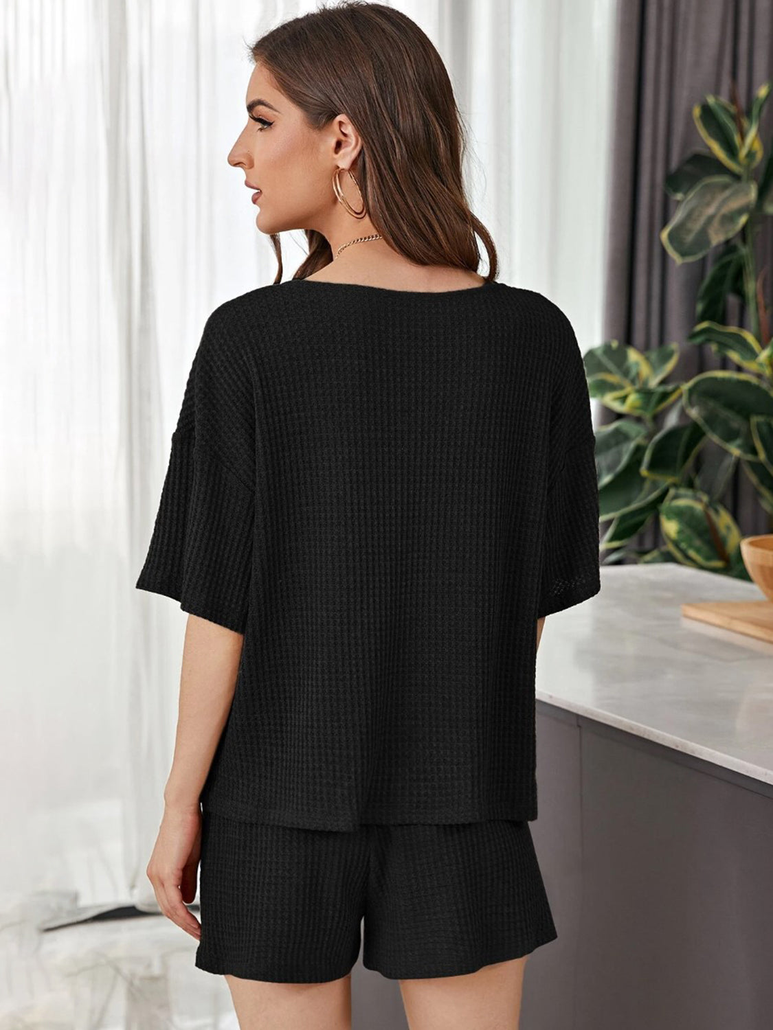 Black waffle knit henley loungewear set with short sleeves and shorts.