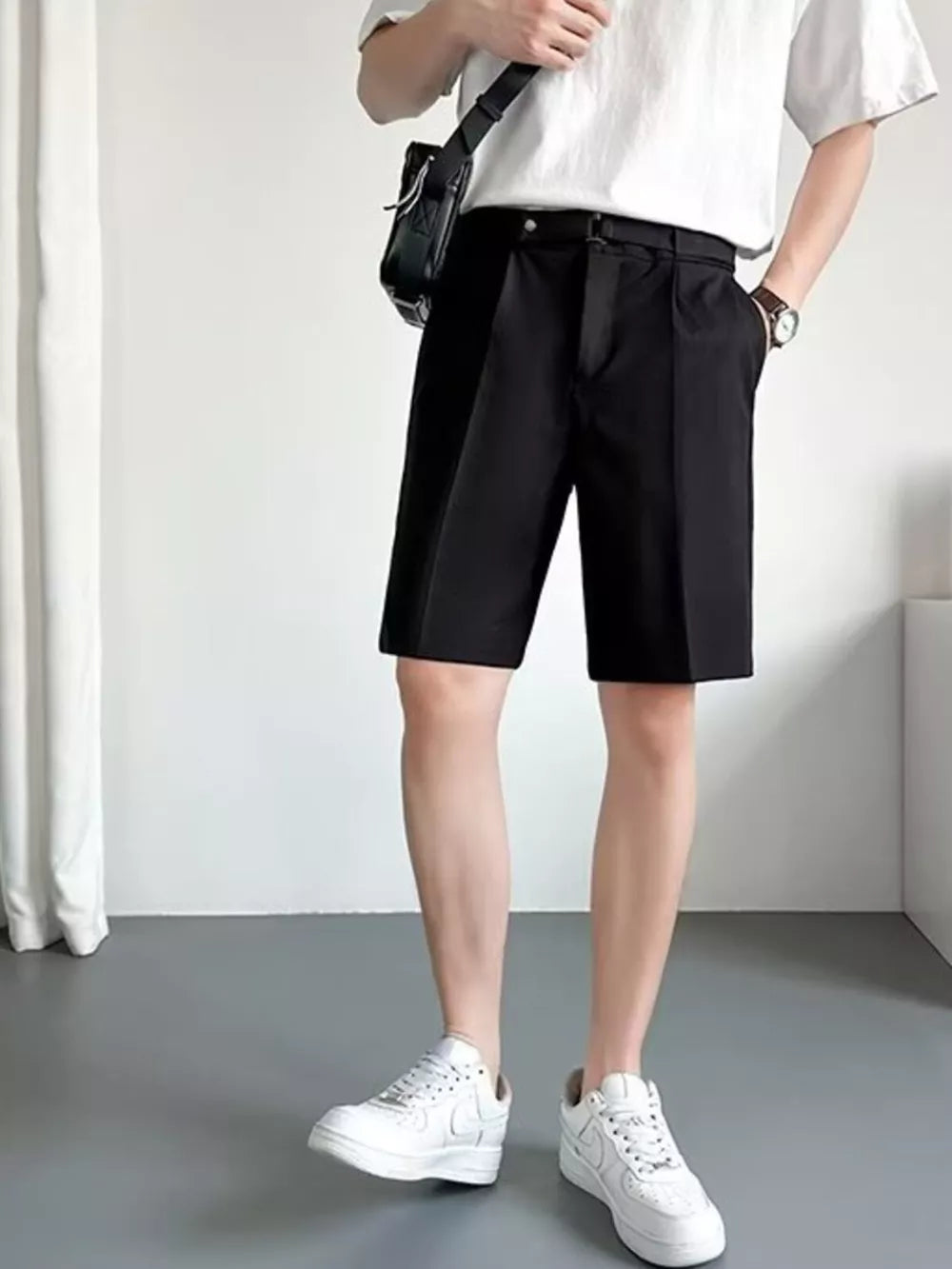 Black belted chino shorts with pleats and a relaxed fit.