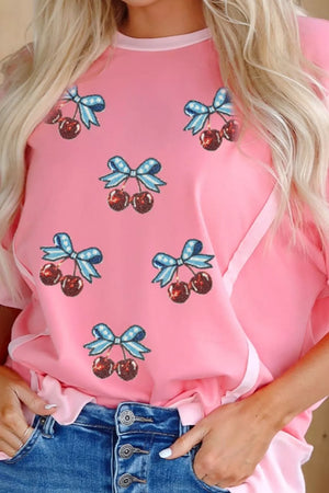 Pink polyester t-shirt with sequin cherry and bow graphic print.