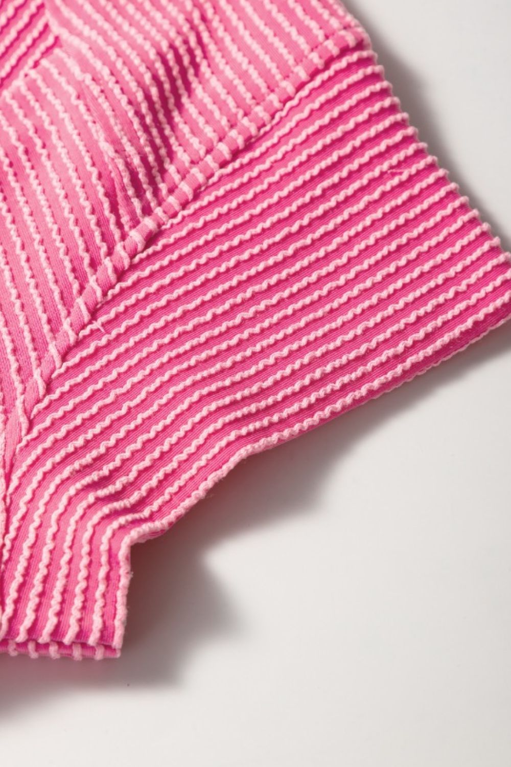 Fuchsia pink ribbed knit co-ord set detail showing textured stripes and stitching.